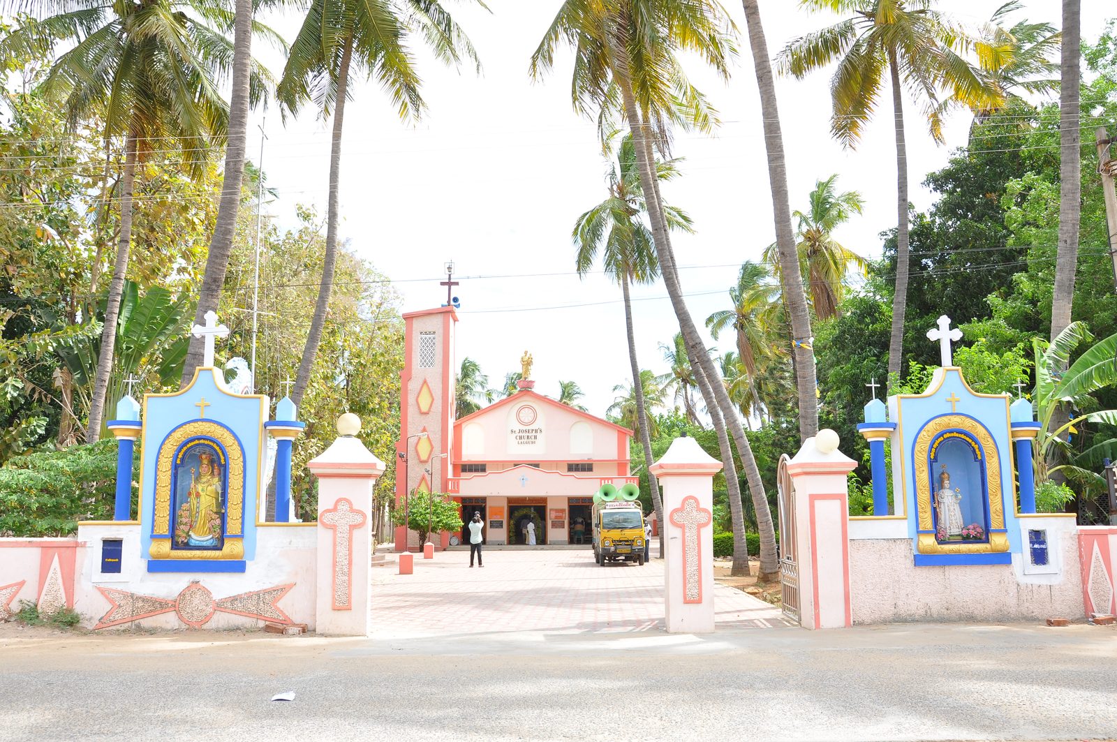 The church entrance gate flanked by wayside shrines